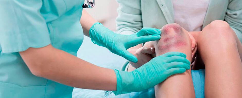 Un medico esamina una lesione al ginocchio